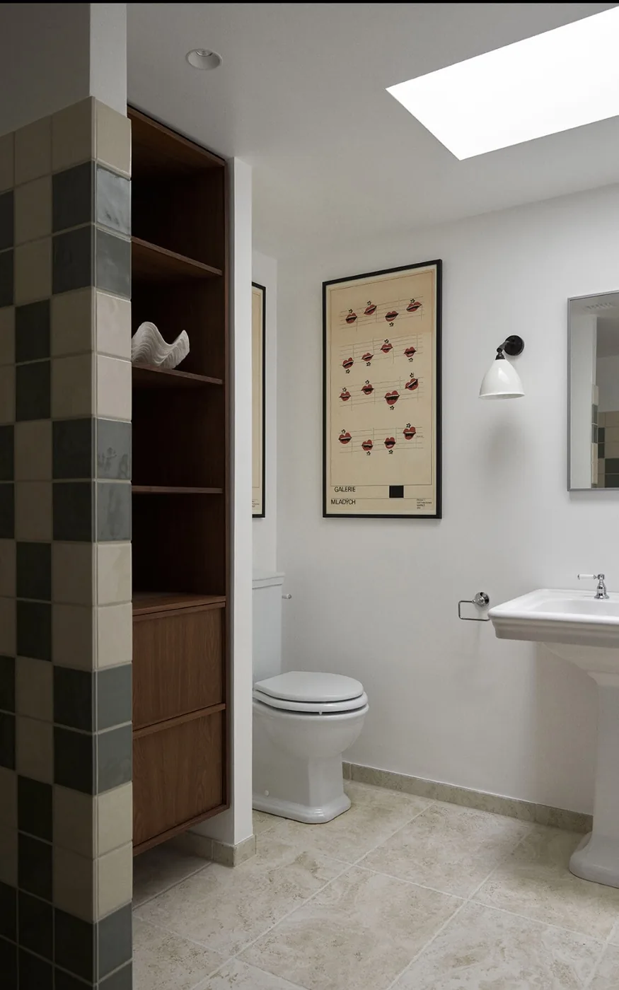 Badeværelse i Hillerød efter renovering med ternede fliser, ovenlys og indbygget reol i træ